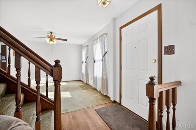 Foyer entrance with light wood finished floors, stairway, and ceiling fan