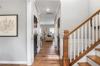Corridor featuring ornamental molding, wood finish