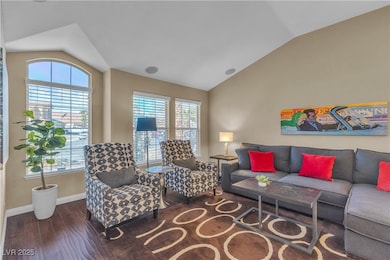 Living area featuring baseboards, lofted ceiling,