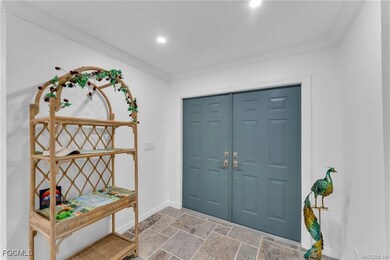 Entrance foyer with ornamental molding and light stone finish flooring