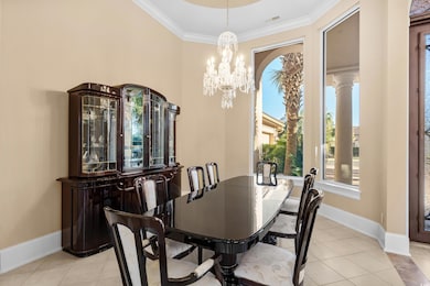 Dining area with healthy amount of natural light, ornamental molding, a chandelier, and light tile patterned flooring