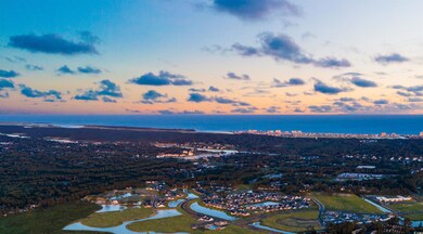 Aerial view at dusk featuring a water view