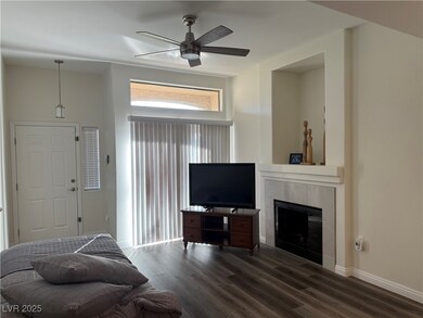 Living room featuring a fireplace, wood finished floors, and ceiling fan