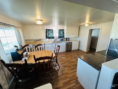 Dining space with dark wood-style floors and baseboards