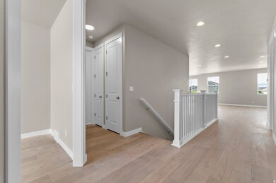 Corridor featuring an upstairs landing, recessed lighting, and light wood-style floors