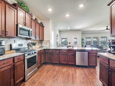 Gas range, LVP flooring, stainless appliances, extended granite countertops with room for bar stools.