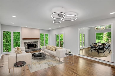 Living room with healthy amount of natural light, wood finished floors, a premium fireplace, and recessed lighting