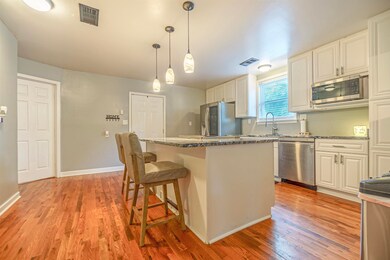 Kitchen featuring white cabinetry, light hardwood 