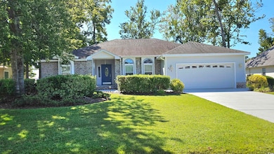 Single story home featuring a front yard, a garage, a shingled roof, driveway, and brick siding
