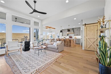 Living area featuring a barn door, recessed lighting, light wood finished floors, and ceiling fan