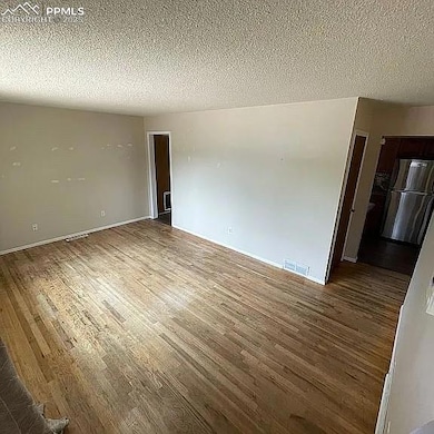 Unfurnished room with wood finished floors and a textured ceiling