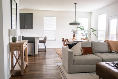 Living area with dark wood-style floors and baseb