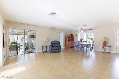 Living room with ceiling fan and light tile patter