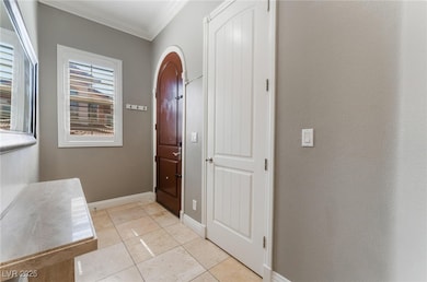 Entrance foyer with baseboards, crown molding, and