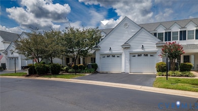 View of front facade featuring driveway, a garage, and roof with shingles