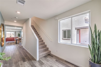 Stairs with wood finished floors, baseboards, and
