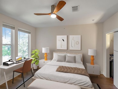 Bedroom with wood finished floors, an office area