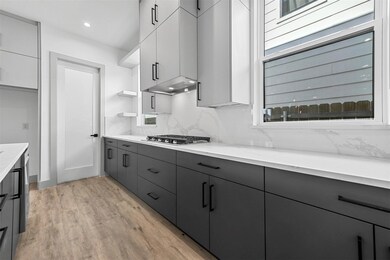 Kitchen featuring gray cabinets, white cabinets, s