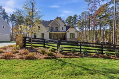 View of front of house featuring stone siding, a fenced front yard, board and batten siding, and a porch