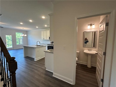 Kitchen with stainless steel range with electric stovetop, a center island with sink, dark wood-style flooring, recessed lighting, and a chandelier