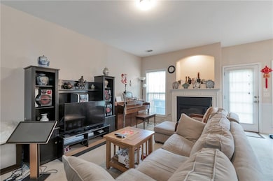 Carpeted living room with a glass covered fireplace