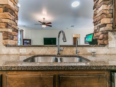 Kitchen with dark stone countertops, tasteful back