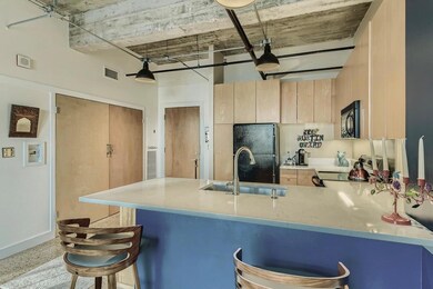 Kitchen featuring light brown cabinets, black app