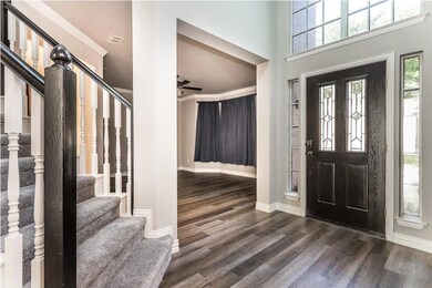 Entryway featuring dark wood finished floors, crown molding, stairway, and a high ceiling