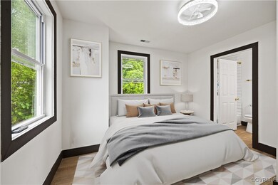 Bedroom with multiple windows, light wood-style fl