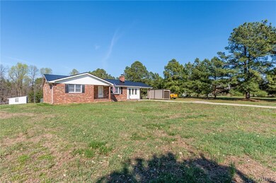 View of large front yard featuring a storage shed