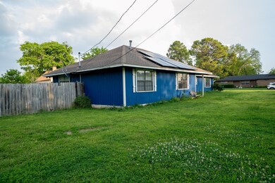 View of side of home with a yard and solar panels