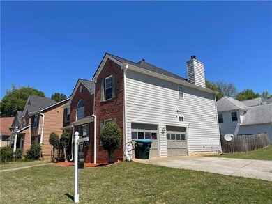 View of side of property with a yard, an attached 