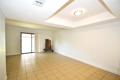 Empty room with a tray ceiling and light tile pat
