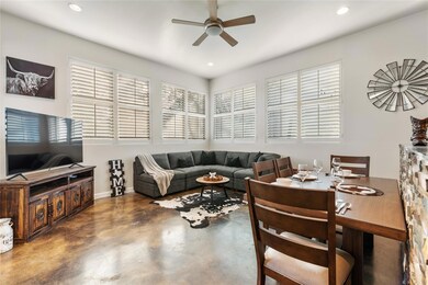 Living room with a ceiling fan, concrete floors, 