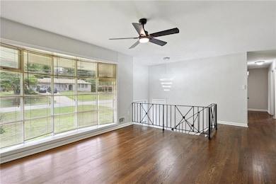 Empty room featuring dark wood finished floors and ceiling fan