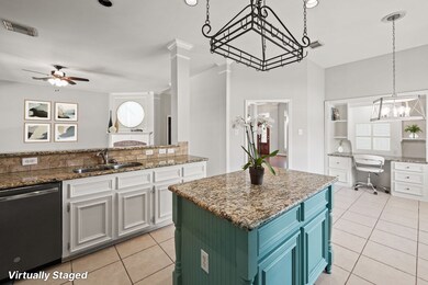 Centrally located the kitchen offers views of the living, dining and laundry rooms with the bonus of a built in  crafting/household management/desk with shelves and additional cabinet/drawer storage. Virtually Staged Photo.