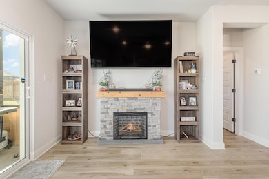 Living area with wood finished floors, a stone fi