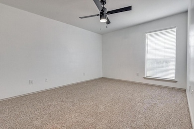 Carpeted empty room featuring baseboards and a cei