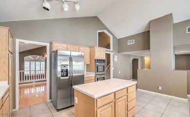 Kitchen featuring light brown cabinetry, appliance