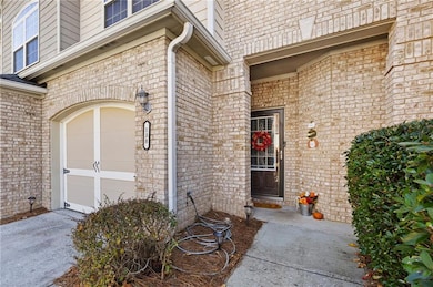 Property entrance with brick siding and an attached garage