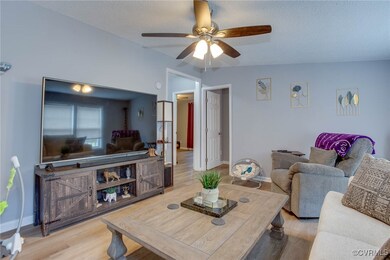 Living room with a ceiling fan, wood finished floo