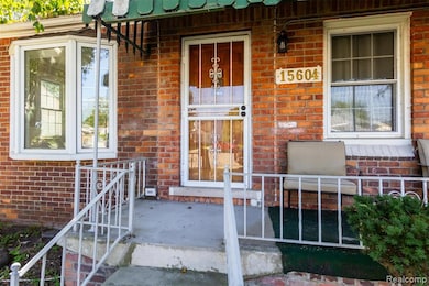 Property entrance featuring brick siding and covered porch