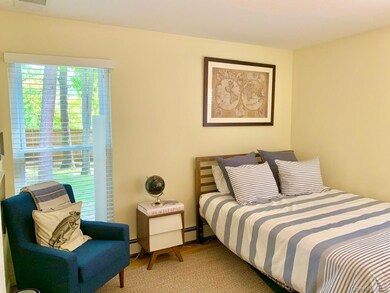 Bedroom with wood finished floors and a baseboard radiator