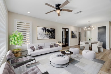 Living area featuring recessed lighting, wood finished floors, a ceiling fan, and a chandelier