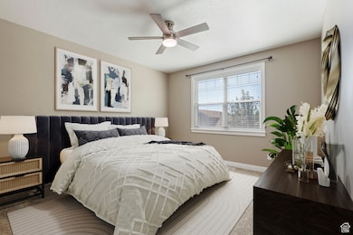 Carpeted bedroom featuring a textured ceiling and ceiling fan