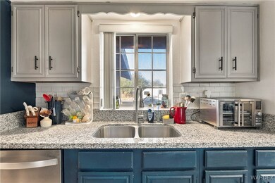 Kitchen with decorative backsplash, light stone co
