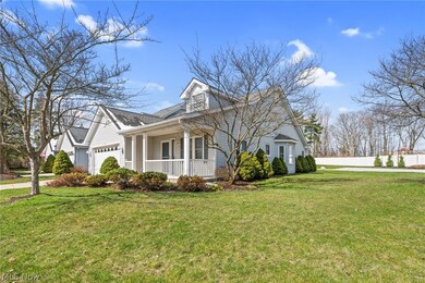 View of front facade featuring covered porch, a front yard, and a garage