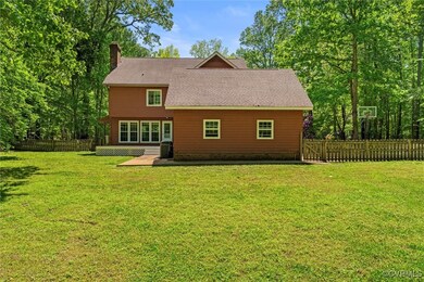 Rear view of house with fence, a chimney, a lawn,
