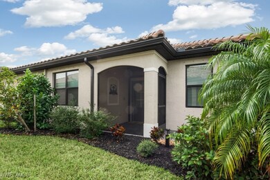 View of exterior entry with stucco siding, a lawn,