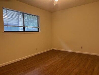 Unfurnished room with dark wood-type flooring, ba